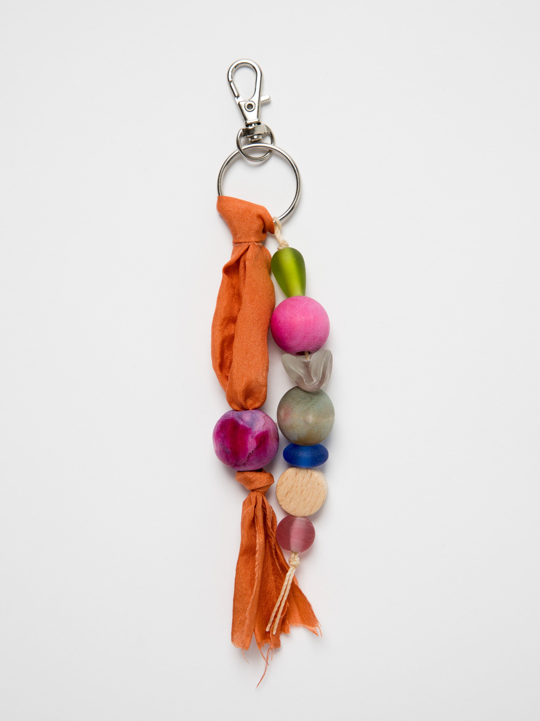 Colorful wood and glass beaded keychain with orange silk ribbon on a white background