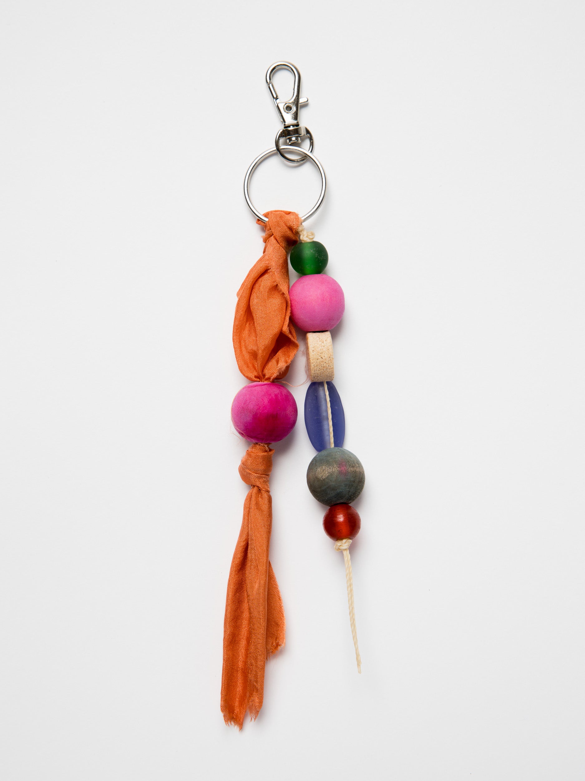 Colorful keychain with wood and glass beads and silk on a white background