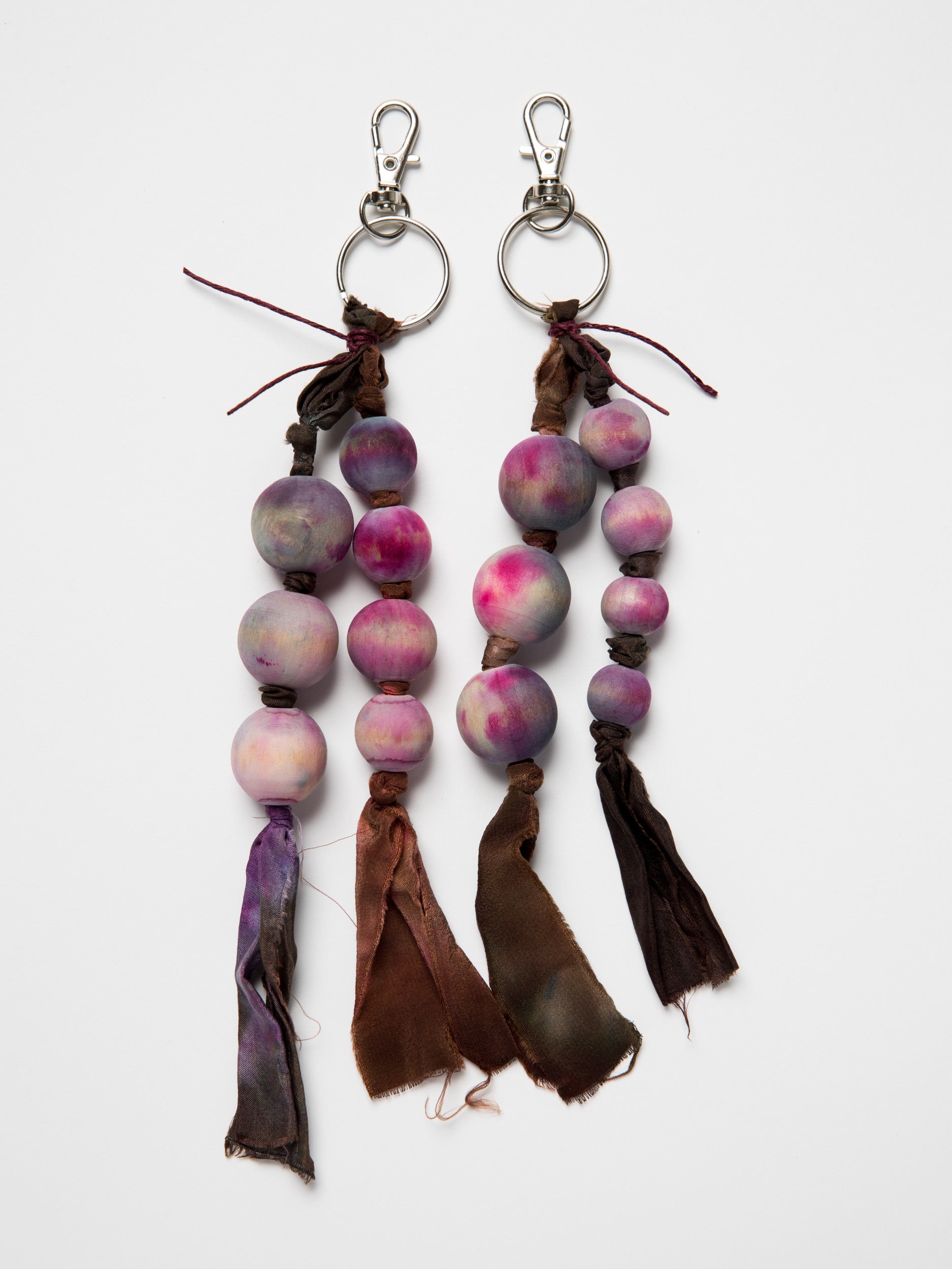 Handmade bag charms made with wooden beads and silk ribbons  on a white background